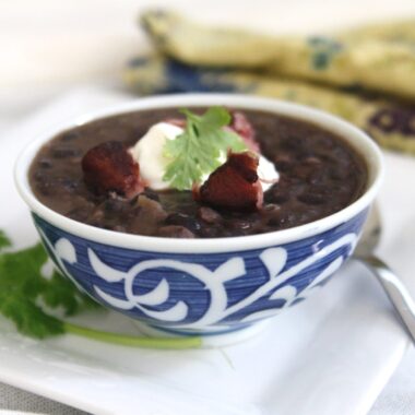 Cuban Black Bean Soup with Smoked Ham Hock is made with black beans simmered with smoked ham hocks and aromatic ingredients like onions, garlic, bell peppers, and spices. The infusion of flavors creates a deeply satisfying and robust soup.