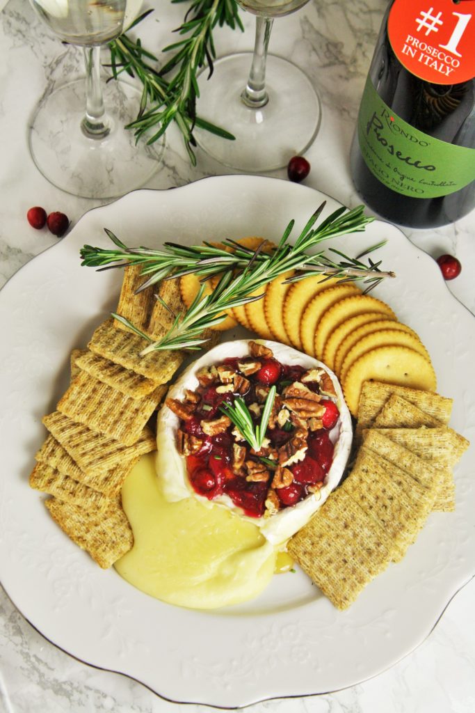 Warm, gooey baked brie topped with tart cranberry sauce, roasted pecans, honey and rosemary. A truly classic appetizer served up for the holidays