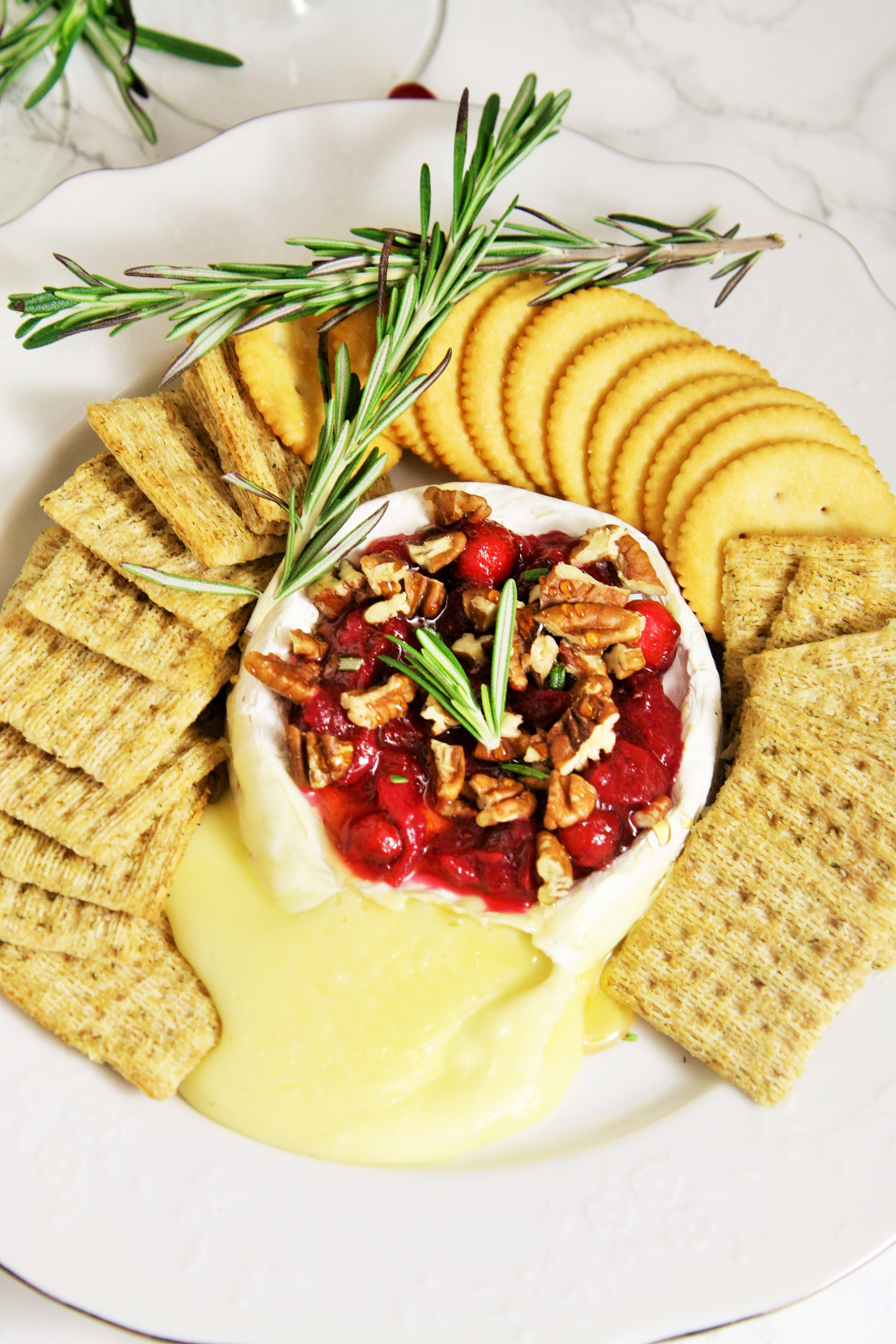 Warm, gooey baked brie topped with tart cranberry sauce, roasted pecans, honey and rosemary. A truly classic appetizer served up for the holidays