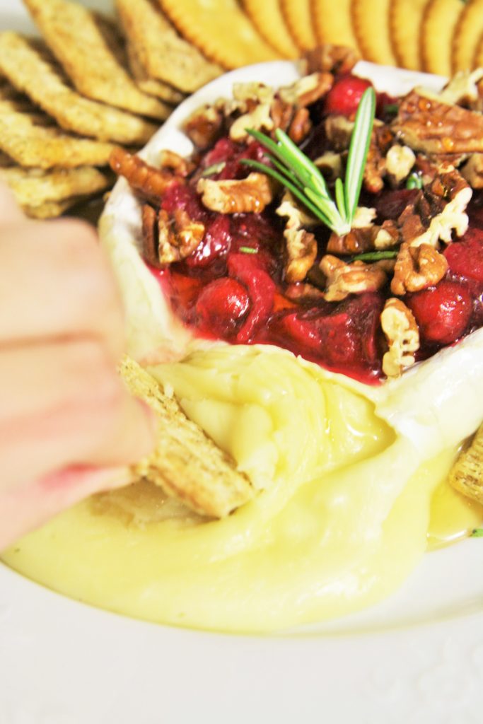 Warm, gooey baked brie topped with tart cranberry sauce, roasted pecans, honey and rosemary. A truly classic appetizer served up for the holidays